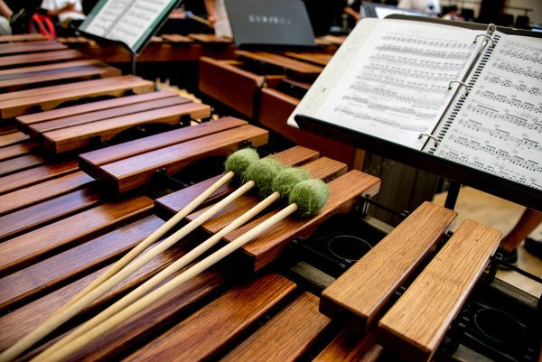 A marimba with four mallets is pictured next to sheet music