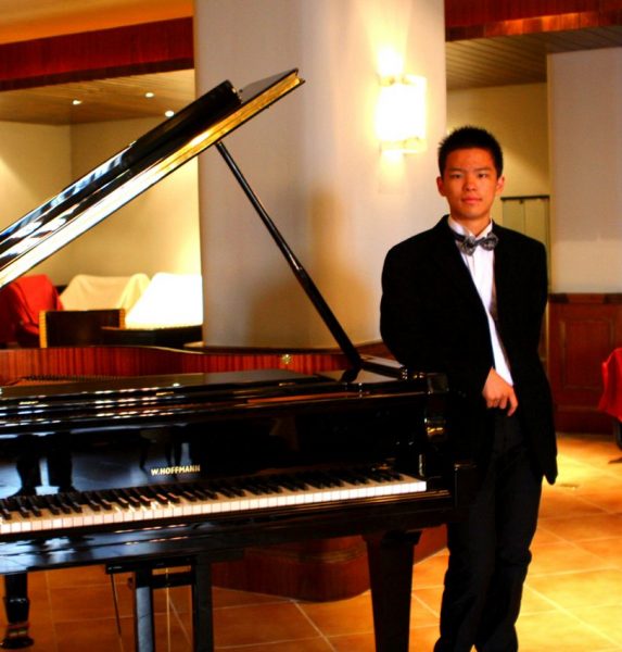 Sicong Zhou pictured next to a grand piano