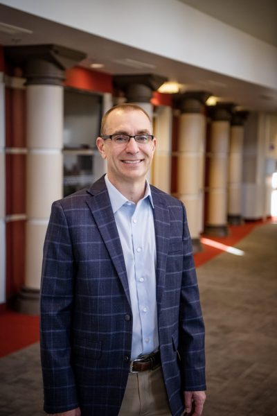 2026 Promotional Photo of Dr. Eric Hollenbeck standing in the Griffin Concert Hall lobby.